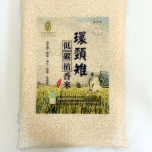 一包真空包裝的白米，包裝中央貼有「環頸雉 低碳植香米」標籤，背景有稻田與環頸雉圖案。
